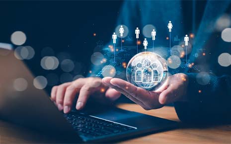 man at laptop holding community icons within a magic globe