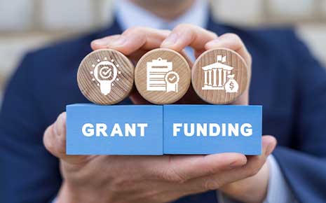 man holding grant funding blocks